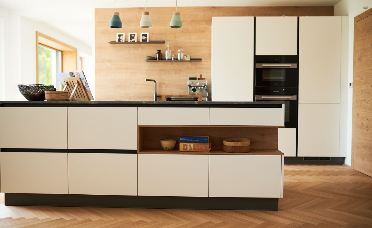 Moderne Küche mit einer zentralen Insel, Holzregalen und eleganten Pendelleuchten. Schränke in Weiß und Holzoptik, Holzfußboden.